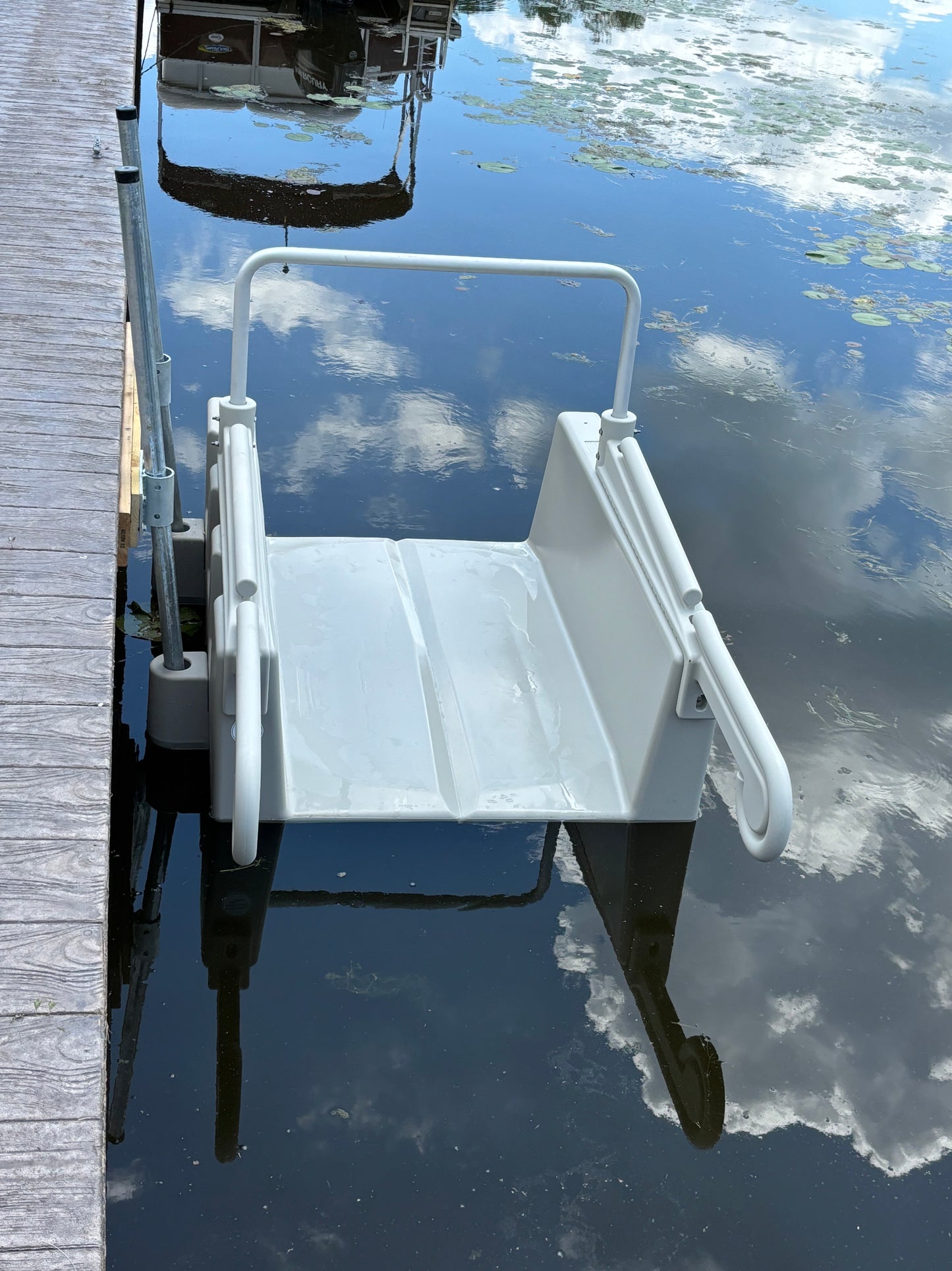 This gray YAKport is installed on a cement seawall using a fixed dock installation kit. Underwater there is a cement ledge sticking out about half a foot, so the poles needed to be installed at an angle to properly support the launch.