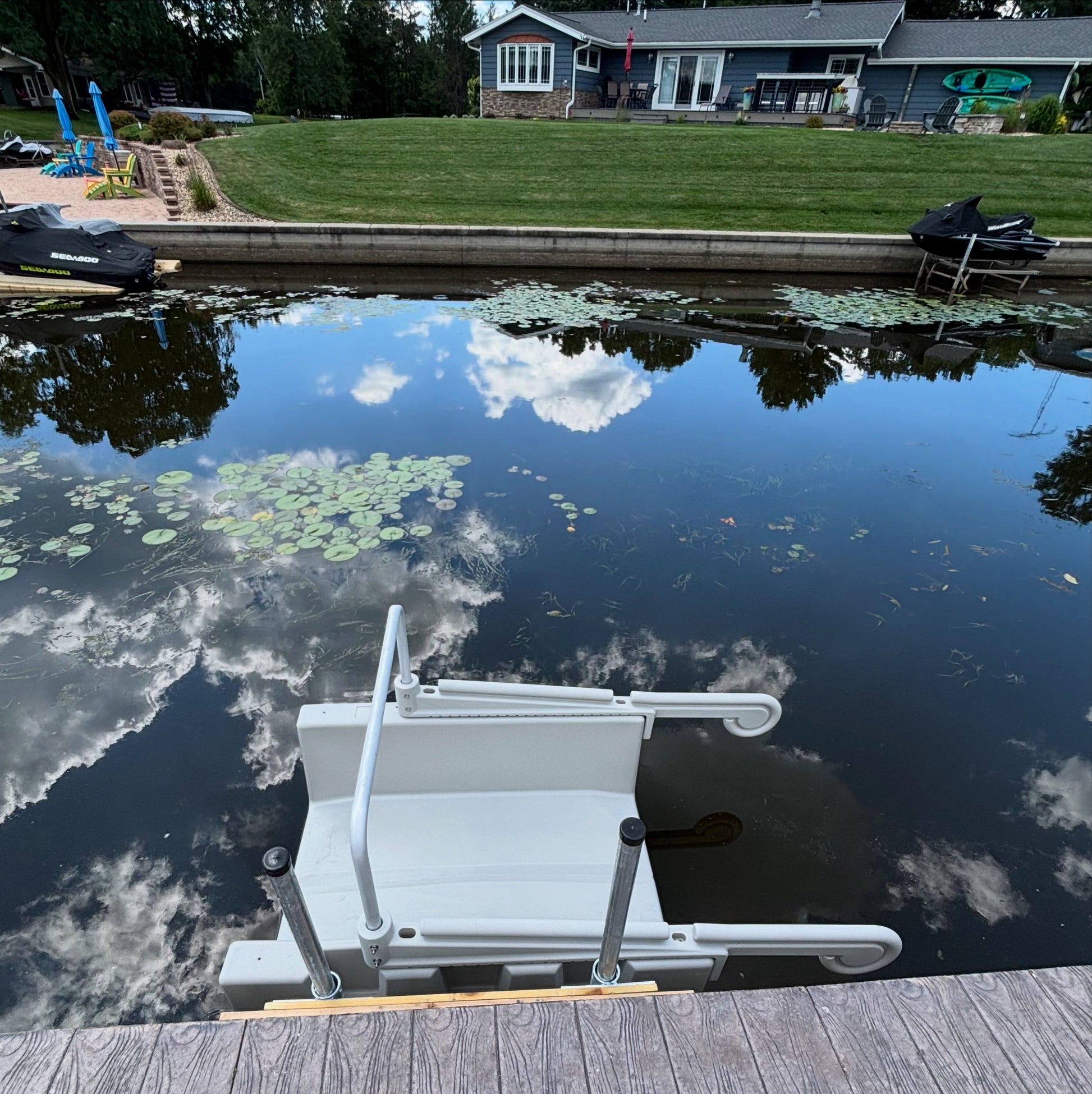 This gray YAKport is installed on a cement seawall using a fixed dock installation kit with 8' poles. Installed in Mauston,  Wisconsin at an Airbnb on Castle Rock Lake.